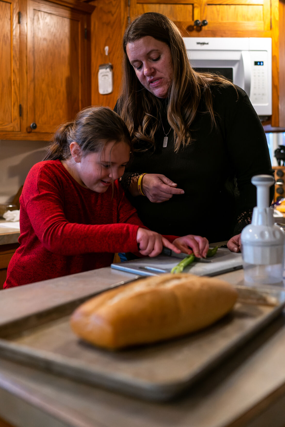 Kristin Rogers, right, teaches her daughter Abby Rogers to cut up celery